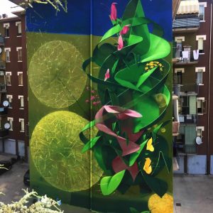 Big wall painting on building with green leaves and pink flowers. Total building view. Aerosol art by Dado
