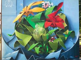 Graffiti-mural painting spheric lettering with multi colored flowers-front view. Artwork by Dado