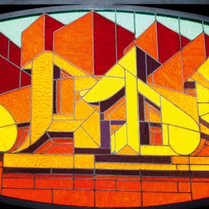 A stained glass window made colored glass pieces representing the word Dado in a graffiti style at the bottom of stylized skyscrapers.