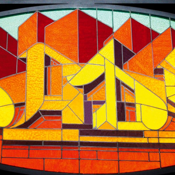A stained glass window made colored glass pieces representing the word Dado in a graffiti style at the bottom of stylized skyscrapers.