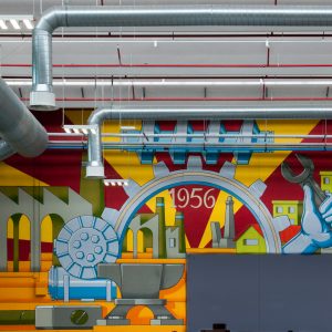 Detail of a big wall painting representing the company first logo in the factory warehouse interior. Wall painting by Dado.