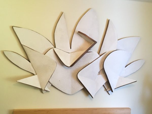 Bas-relieff representing a letter P and a letter G surrounding an heart in the middle and some abstract cloud-like element in the background, front view. Artwork by Dado.