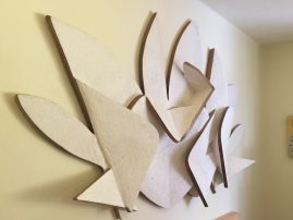 Bas-relief representing a letter P and a letter G surrounding an heart in the middle and some abstract cloud-like element in the background, left view. Artwork by Dado.