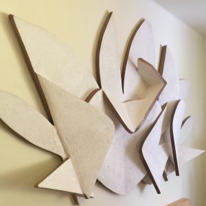 Bas-relief representing a letter P and a letter G surrounding an heart in the middle and some abstract cloud-like element in the background, left view. Artwork by Dado.