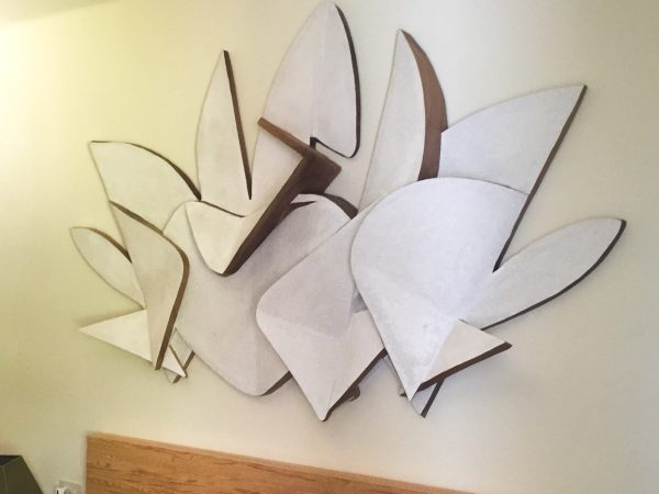 Bas-relief representing a letter P and a letter G surrounding an heart in the middle and some abstract cloud-like element in the background, right view. Artwork by Dado.