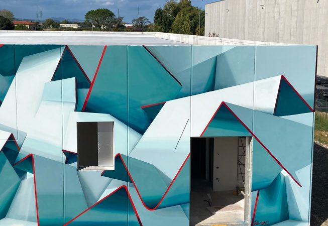 Detail of a graffiti paint work on the external walls of a big building representing flat ribbons bent in geometrical shapes, light blue and white shades with thin red outlines. Artwork by Dado