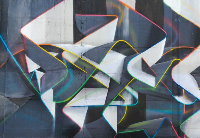 Mural painting representing weaving stiff ribbons forming the name of the artist Dado, in dark grays and white tones with sharp cutting multi color outline. Core detail