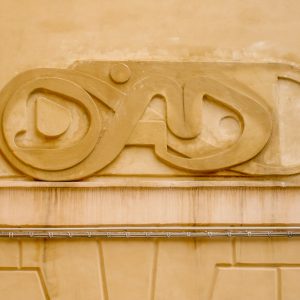 Bas-relief sculpture in a contemporary graffiti lettering fixed on a above a Medieval vault architecture well pairing. Front view detail. Artwork by Dado