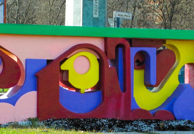 A graffiti style bright colored sculpture built to be installed in the middle of a traffic circle in a public road path. Artwork by Dado