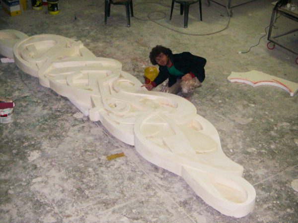 Bas-relief sculpture in a contemporary graffiti lettering plain white rough cement with the artist Dado