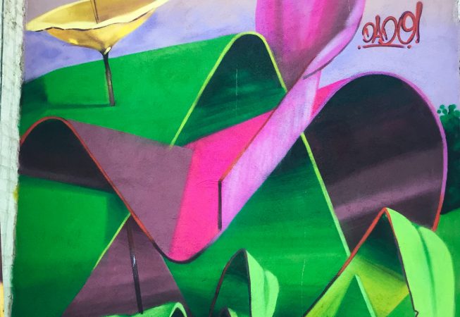 A triptych mural painting of flowers in three different colors on a white bricks wall in a wide open space, single flower view. Artwork by Dado