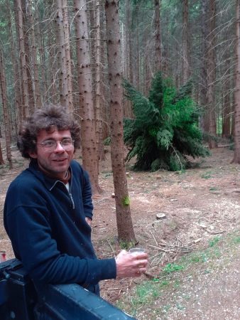 The artist Dado in the forest with one of his organic dandelion installations in the background.
