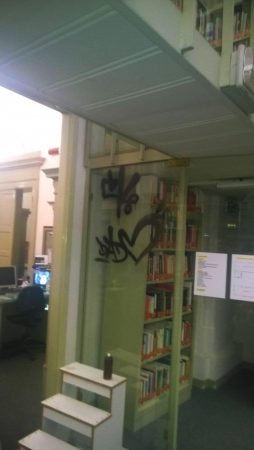 Main entrance of an art gallery where the artists featured at the exhibitions wrote their tags with spray cans on the main glass door. Tags by Dado and CK8.