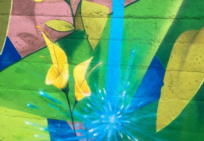 Detail of yellow flowers and falling water on a Mural Painting depicting the name of the city Covignano woven with colored flowers and green leaves. Artwork by Dado