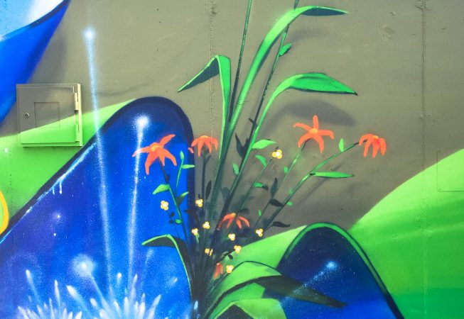 Detail of a mural painting depicting wide sinuous blue ribbons decorated with purple flowers and green leaves and water splashes. Artwork by Dado