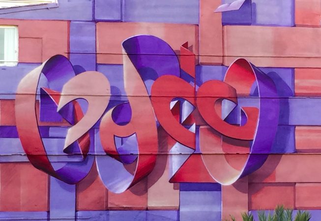Detail of a mural depicting floating bent ribbons creating two names altogether the tag Dado and the name Eva in a pale red and electric blue tones