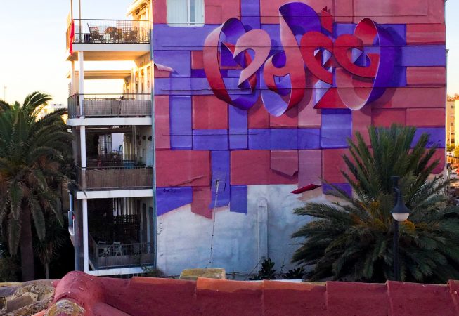 An high building at the dawn with a big mural painting depicting floating bent ribbons creating two names altogether the tag Dado and the name Eva in a pale red and electric blue tones